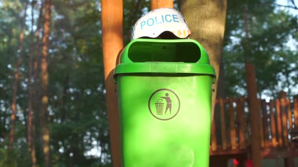 Зеленый мусор, на котором лежит шлем с надписью полиции — стоковое видео