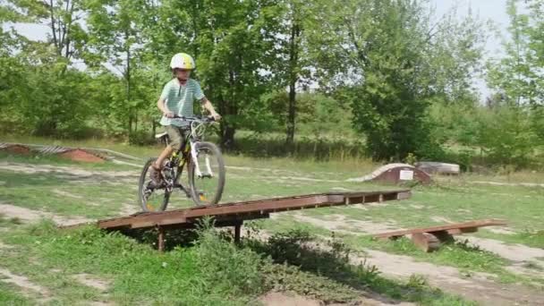 Велосипедист школяр їде на перешкодний баланс гойдалки гірський велосипед — стокове відео