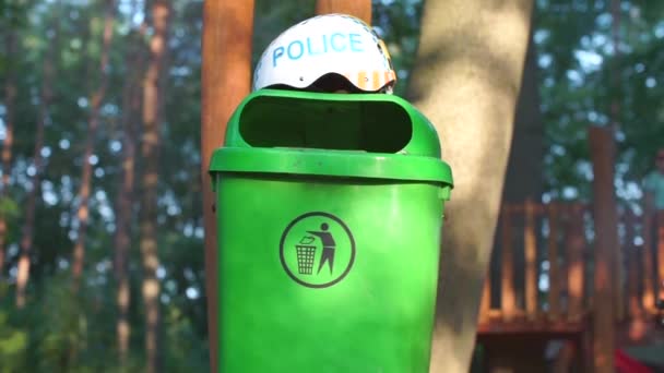 Helm met de inscriptie politie ligt op een groene vuilnis — Stockvideo