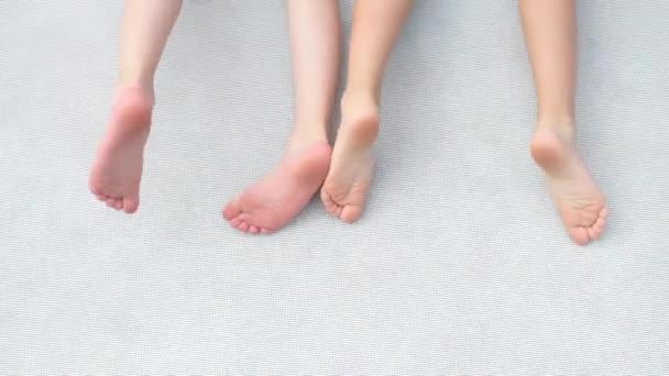 Ένα ζευγάρι παιδικά πόδια αιωρείται σε ένα τραμπολίνο στην παιδική χαρά — Αρχείο Βίντεο