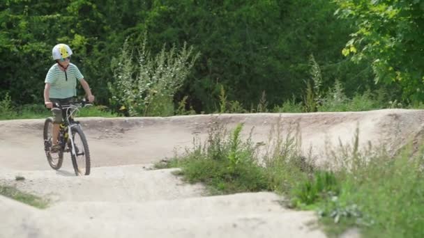 Niños montan bicicletas en una colina en competiciones — Vídeo de stock