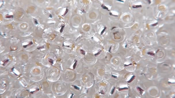 Verser des perles claires dans un sac. Vente de perles de bijoux .