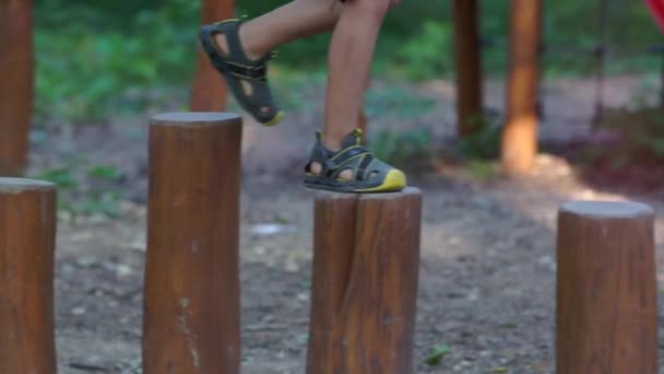 The boy walks along the path of stumps — Stock Video