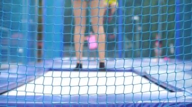 Okul bahçesinde spor sayfası, çocuklu bir öğretmen zıplıyor.