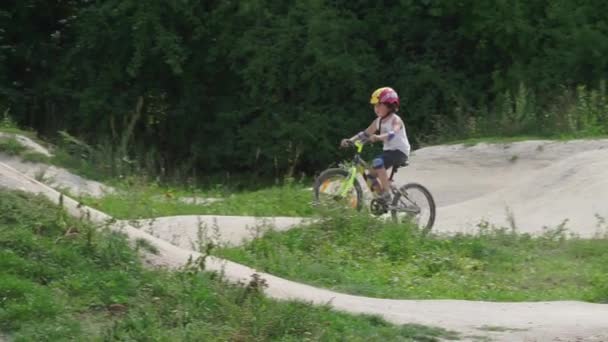 Chłopiec w kasku na rowerze górskim jeździ na torze do konkursów szkolnych — Wideo stockowe