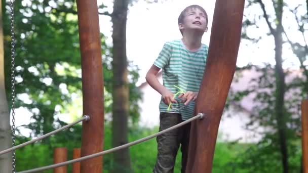 Хлопчик розповідає вірш, стоячи на дитячому майданчику — стокове відео