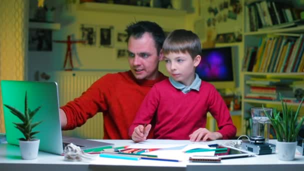 Um pai explica o conhecimento financeiro ao filho numa mesa do escritório. . — Vídeo de Stock