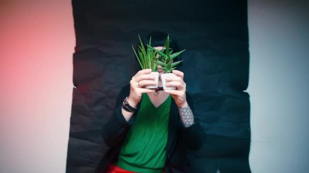 A blogger greets his followers. Holding plants in his hands, the Devon Rex cat. — Stock Video