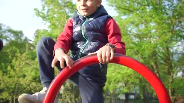 Menino feliz salta sobre um obstáculo no playground da escola — Vídeo de Stock