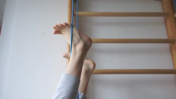 Chłopiec wiszący do góry nogami na pierścieniach gimnastycznych — Wideo stockowe