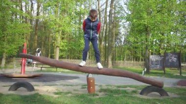 Çocuk okul bahçesinde salıncakta sallanıyor.