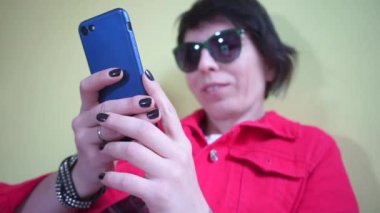 Mesajı yazan bir kızın elindeki akıllı telefonun yakın plan görüntüsü.