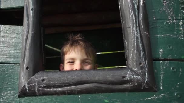 Närbild av en pojkes ögon kikar ut genom ett fönster — Stockvideo