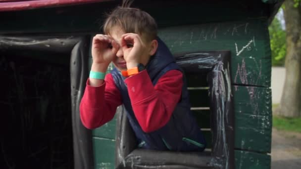 Дитина дивиться в його руки імітує бінокль, дивиться з вікна — стокове відео