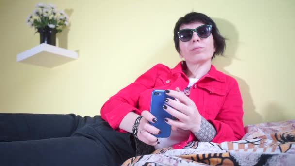 Kvinna väntar skriver ett meddelande på en smartphone — Stockvideo