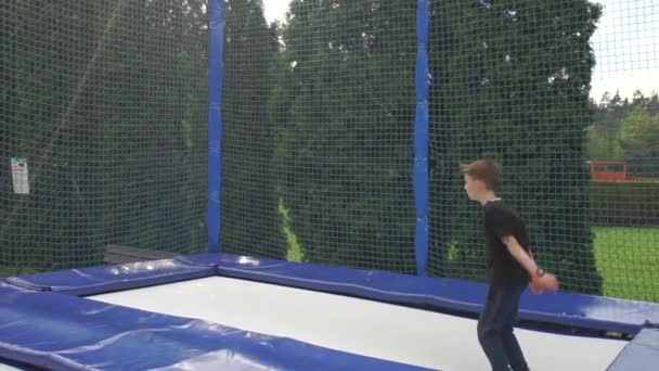 Chico saltando en un trampolín en un parque deportivo — Vídeos de Stock