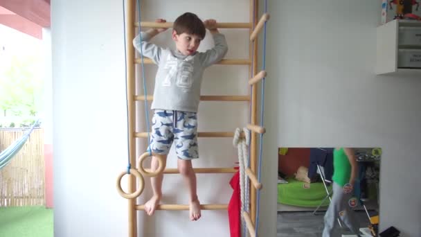 Kinderen doen oefeningen op de Zweedse muur in de kamer — Stockvideo