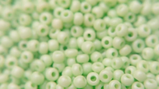 Beyaz bir tabağa yeşil boncuklar dökülüyor.. — Stok video