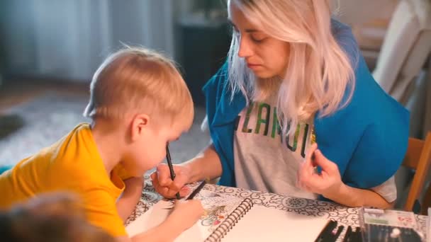 Mamá dibuja en la mesa con su hijo dibujando zendoodling — Vídeo de stock