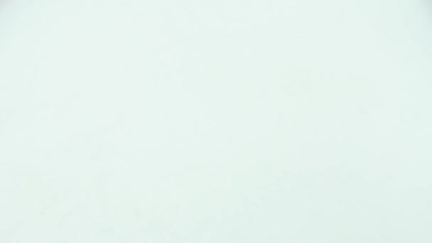 Verser des perles blanches dans une assiette blanche .