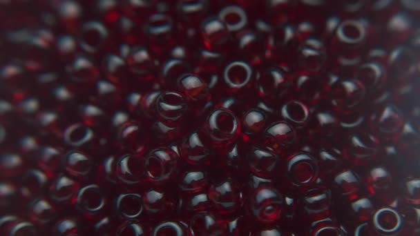 Versare le perle rosso scuro in un piatto bianco . — Video Stock