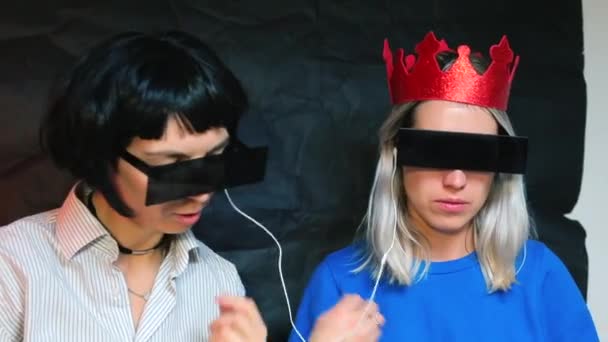 Dos chicas comienzan a escuchar música de los auriculares . — Vídeo de stock