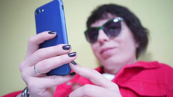 Smartphone blu nelle mani di una ragazza in rosso — Video Stock