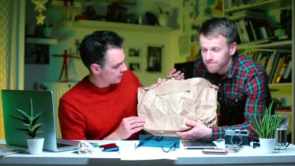 Dos hombres de negocios están discutiendo una bolsa de papel para productos . — Vídeo de stock