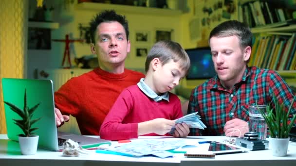Dos parejas gay con su hijo pintan un presupuesto familiar . — Vídeo de stock