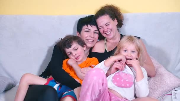 Portrait of two sisters with children on a sofa. — Stock Video