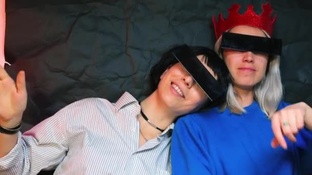 Duas meninas em óculos pretos em um fundo preto em um clube em uma festa . — Vídeo de Stock