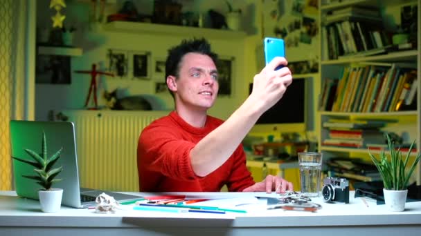 Biznesmen siedzi przy stole i robi selfie na smartfonie. — Wideo stockowe