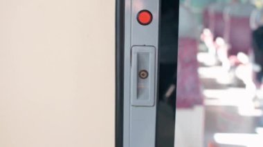 Bir elin yakın duruşu metro kapısının düğmesine basar..