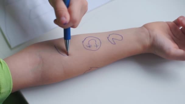 Le garçon dessine un stylo sur sa main un signe de coeur . — Video