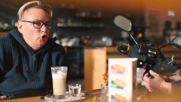 Frau sitzt in einem Restaurant Fratzen. — Stockvideo