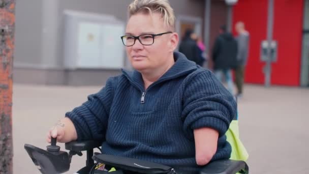 Mulher sem braços dirige uma cadeira de rodas — Vídeo de Stock