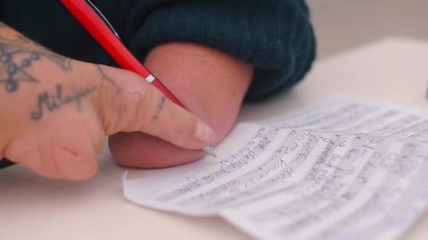 Hombre discapacitado con falta de manos firma un documento en una mesa en la oficina . — Vídeos de Stock
