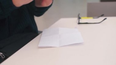 Elleri olmayan bir adam ofis masasına kalem koyar..