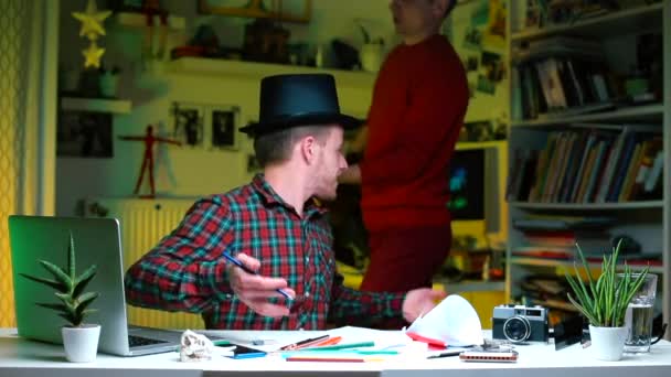 Un homme en haut-chapeau sur la tête s'assoit à une table dans le bureau, travaille avec des documents — Video