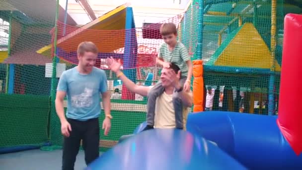 LGBT, família no parque infantil. O parceiro salta sobre um obstáculo inflável . — Vídeo de Stock