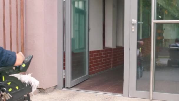 車椅子の障害者が事務所のドアに入る. — ストック動画