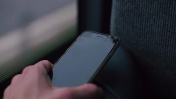 Primer plano de un smartphone en manos de un hombre en un autobús de transporte público . — Vídeos de Stock