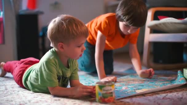 Τα παιδιά παίζουν ένα επιτραπέζιο παιχνίδι στο πάτωμα. — Αρχείο Βίντεο