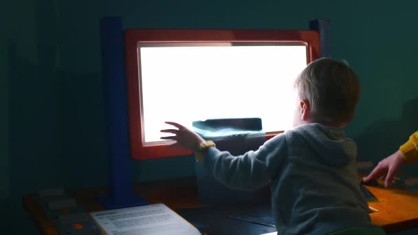 Το παιδί εφαρμόζει μια ακτινογραφία ανθρώπινων οστών στο τείχος προστασίας.. — Αρχείο Βίντεο
