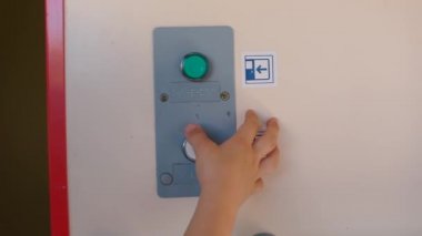Çocuk toplu taşıma treninde kapı tuşuna basıyor..