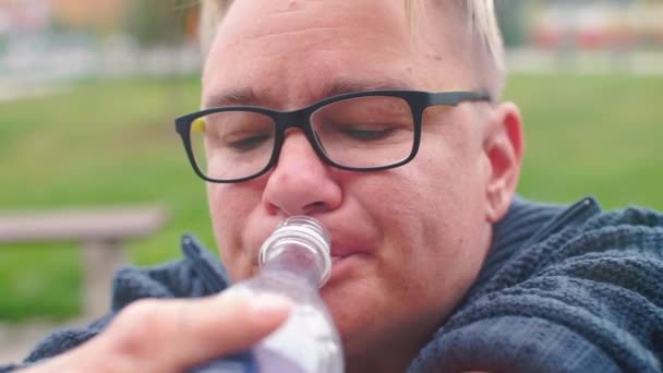 Een vrouw met missende handen sluit het deksel van een plastic fles. — Stockvideo