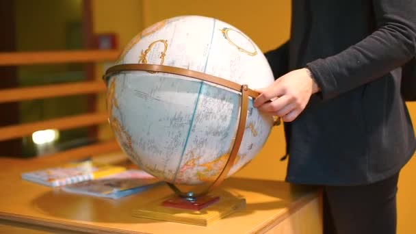 Uno studente sta cercando un paese su un globo . — Video Stock