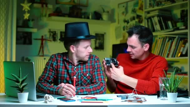 Два фотографа-блогера обсуждают старую кинокамеру . — стоковое видео