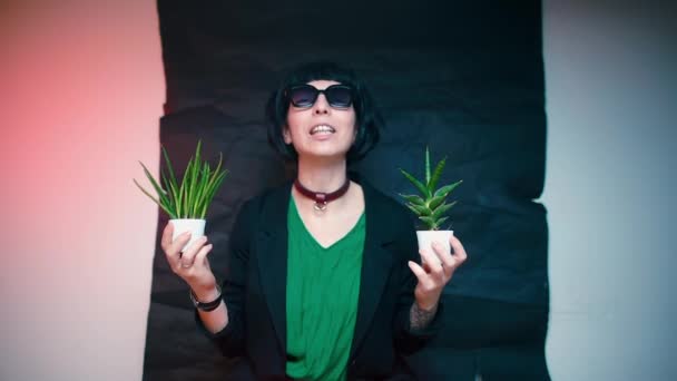 Ta holka mluví o rostlinách. Drží rostliny v rukou. — Stock video