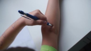 Bebek elinin yakın plan çekimi. El, elin derisine bir kalem çizer..
